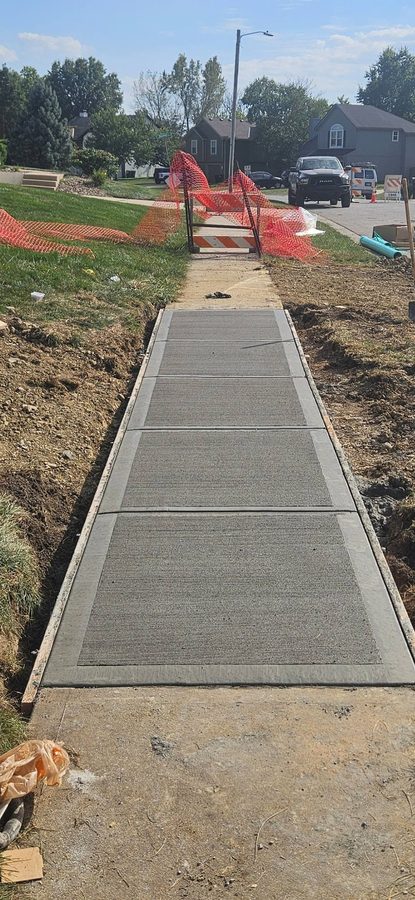 New broom-finished public sidewalk section poured between existing walk, forms still in place